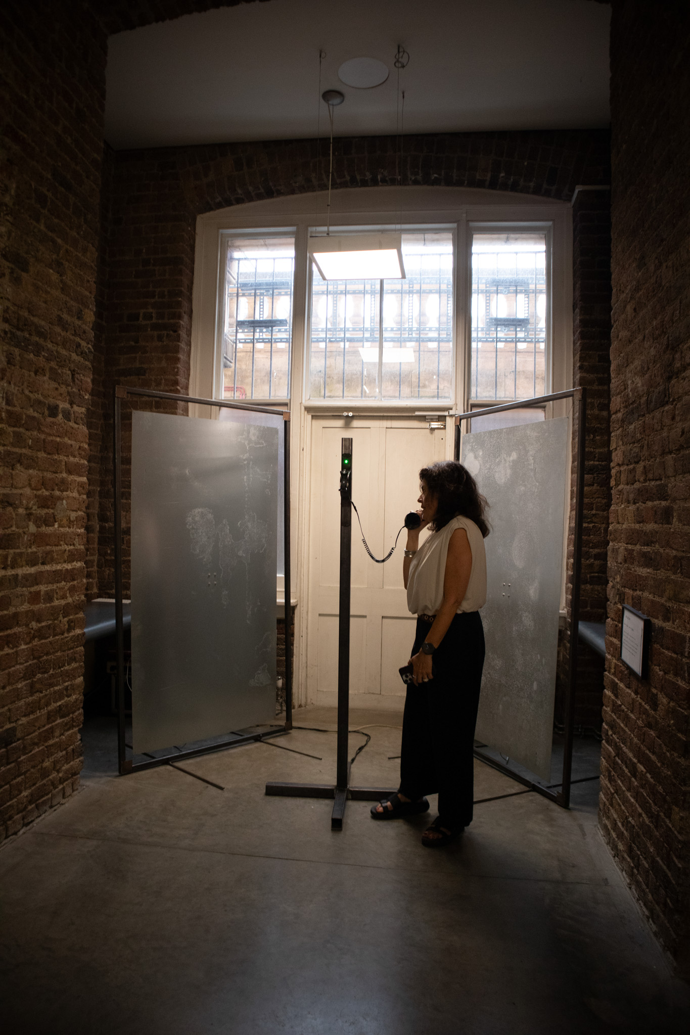 room with metal sheets and a central pole with a phone on it